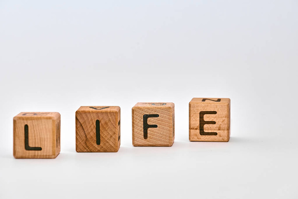 деревянные кубики на белом фоне и слово положил жизнь
 - Фото, изображение