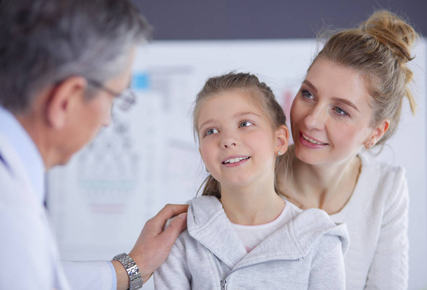 Klein meisje met haar moeder op consult bij een dokter - Foto, afbeelding