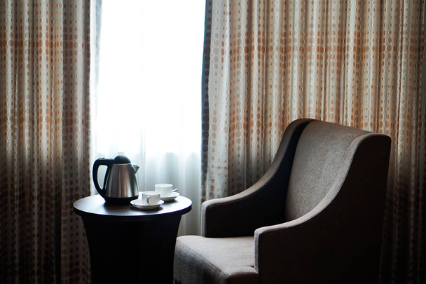 чашка білого чаю чашка кави на столі на дивані в готельному номері, чайник
 - Фото, зображення