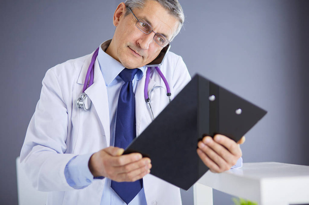 Male doctor writes notes on the clipboard in the hospital - Fotó, kép