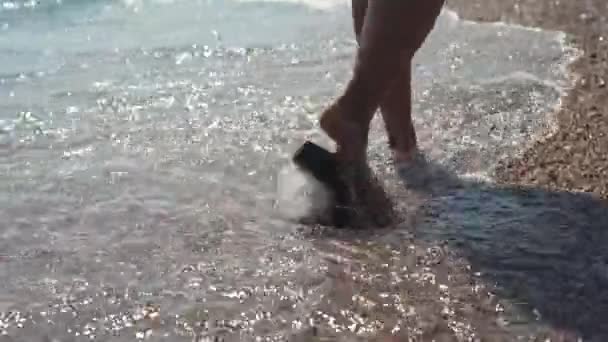 Yakın çekim Kadın ayakları deniz plajında yürüyüş Flip flop Ayakkabı ayakkabılı - Video, Çekim