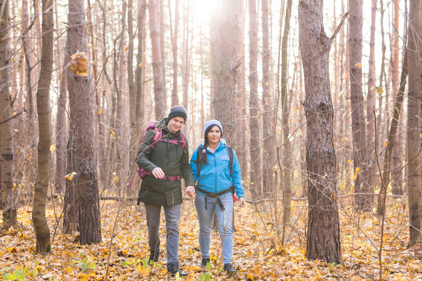 aventura, viagens, turismo, caminhada e conceito de pessoas - casal sorridente andando com mochilas sobre fundo natural outono
 - Foto, Imagem