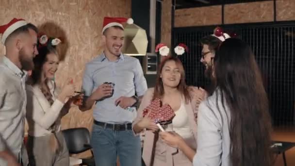 Girl is thanking and hugging her colleagues for Christmas gift on party in office - Footage, Video