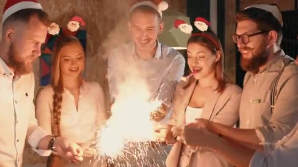 Giovani felici stanno accendendo scintille nella notte di Natale sulla festa e tifo
 - Filmati, video