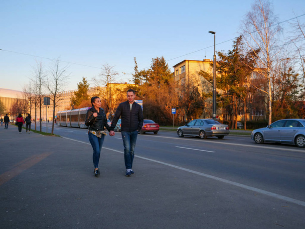 Young couple walking on the sidewalk - Фото, зображення
