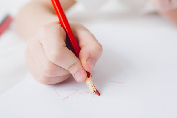 Boy draws with colorful pencils sitting on the bed  - Φωτογραφία, εικόνα
