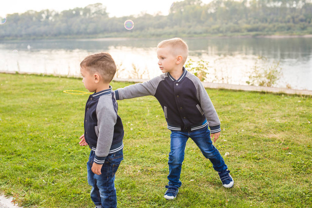 児童コンセプト - カラフルなシャボン玉で遊ぶ 2 人の兄弟の男の子たち - 写真・画像