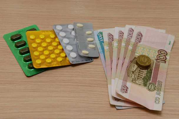 Several drugs and money are on the table. The concept of expensi - Foto, afbeelding