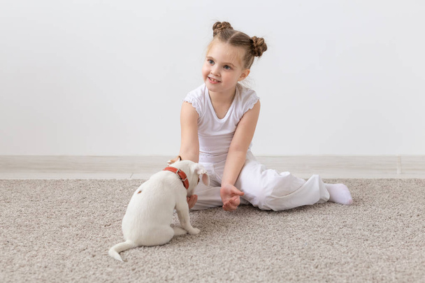 Çocuk ve hayvan kavramı - kız çocuk katta oturan ve köpek yavrusu besleme - Fotoğraf, Görsel