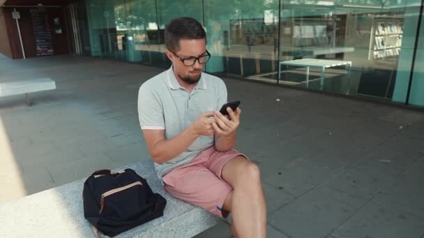 Guy ül smartphone kívül. - Felvétel, videó