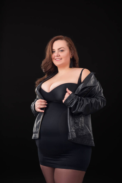 Beautiful young woman plus size with big bust in underwear and Leather Jacket n black background - Fotó, kép
