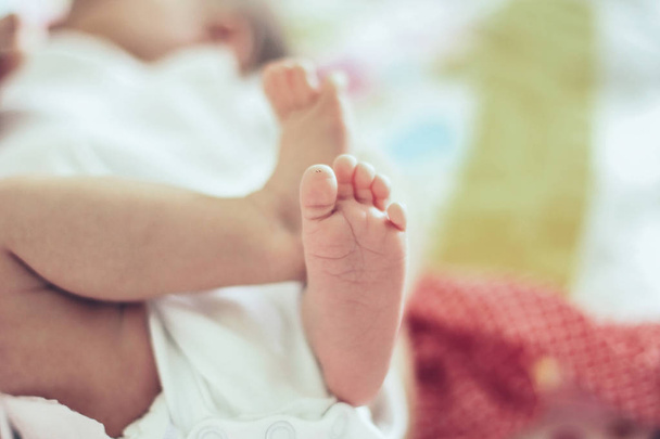 closeup of legs of a newborn baby lying on a blanket in the crib - Foto, Imagem