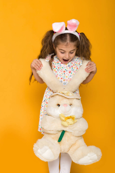 Portrait of cute little child girl with Easter bunny ears holding bunny - Fotó, kép