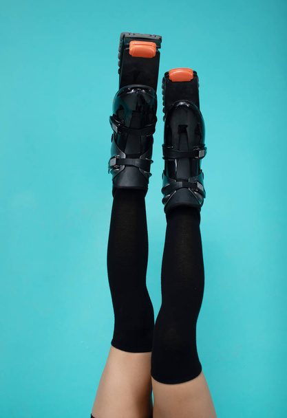 Fit woman legs in jumping shoes on blue background. - 写真・画像