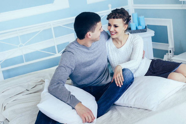 Young happy couple sitting in bed in spacious sleeping room. - Foto, Imagem