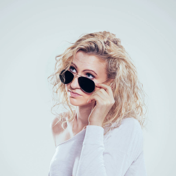 beautiful young blond woman in dark glasses and white sweater - Foto, imagen