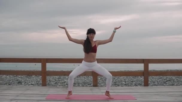 brünette Frau führt tagsüber traditionelle Pose des Hatha Yoga im Freien aus - Filmmaterial, Video