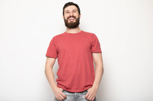 Portrait of young amazed bearded man isolated on gray background - Foto, immagini