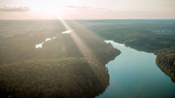 Vue par drone de la forêt et du lac au coucher du soleil
. - Photo, image