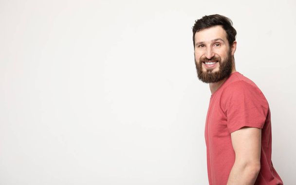 Portrait of young amazed bearded man isolated on gray background - Foto, Imagen