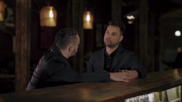 twee mannen in kostuums drink whisky in een bar - Video