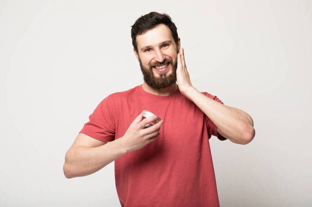 Close-up image of handsome bearded man holding beard balm. - Foto, Imagem