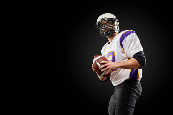 American football sportsman player on black background. Sport concept. - Photo, Image