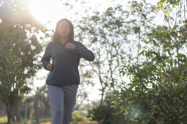 Asian women jogging in the morning garden - Φωτογραφία, εικόνα