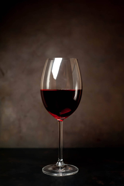 wine glass with red wine on a stone background  - Fotó, kép