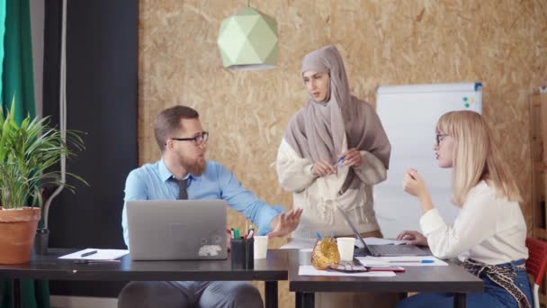 Μουσουλμανική γυναίκα βοηθά τους άνδρες και γυναίκες συναδέλφους της στο γραφείο - Πλάνα, βίντεο