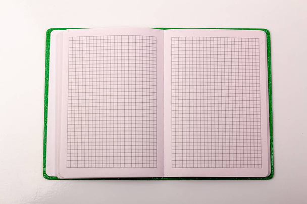 Un cuaderno abierto sobre la mesa sobre un fondo blanco
 - Foto, imagen
