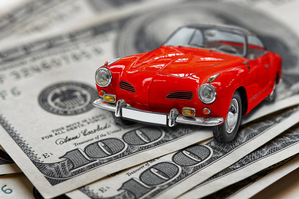 Red toy vintage car on usa or us banknotes closeup - Photo, Image