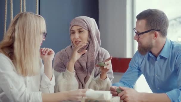 Mujer musulmana está hablando historias a sus amigos hombres y mujeres en la cafetería
 - Metraje, vídeo