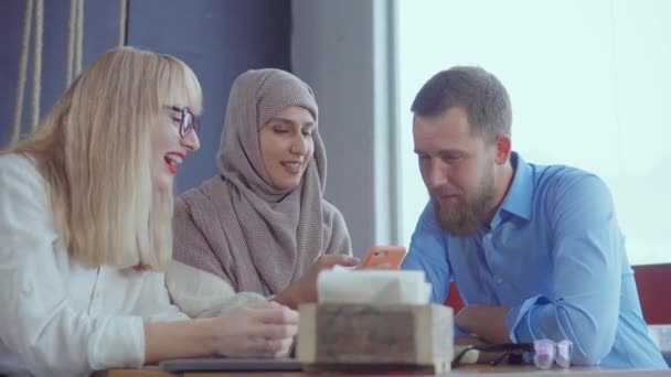 Три разных этнических друга мужчина и женщина болтают в кафе днем
 - Кадры, видео