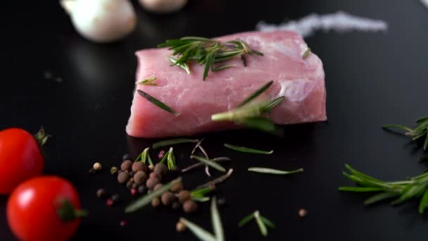 Fresh rosemary being added to raw pork fillet - Кадры, видео