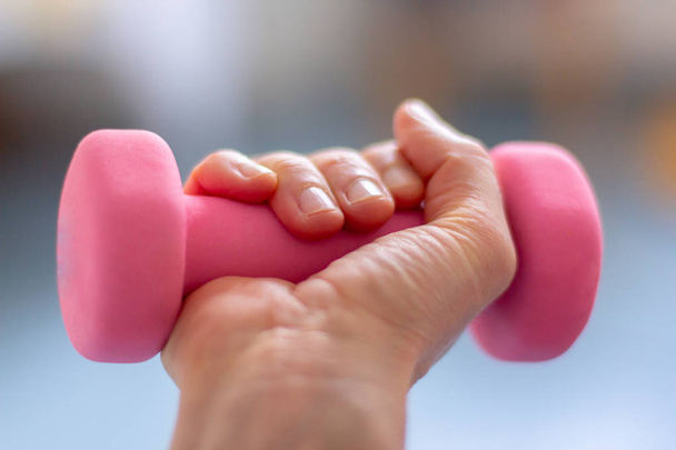 a woman  trains with pink dumb bells - Foto, imagen