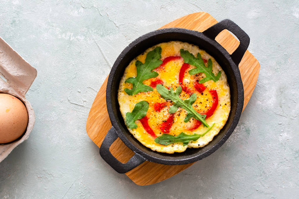 Omelette mit frischem Pfeffer und Rucola. Frittata in der Pfanne. - Foto, Bild