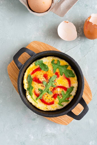 Omelette mit frischem Pfeffer und Rucola. Frittata in der Pfanne. - Foto, Bild