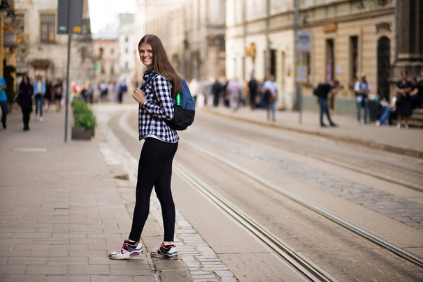 Молода туристична жінка з рюкзаком прогулянка вулицею в старому європейському місті, літній стиль моди
 - Фото, зображення