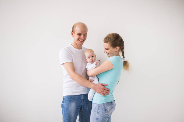 親子関係、愛と家族のコンセプト - 笑顔の母と赤ん坊の娘を持つ父親 - 写真・画像