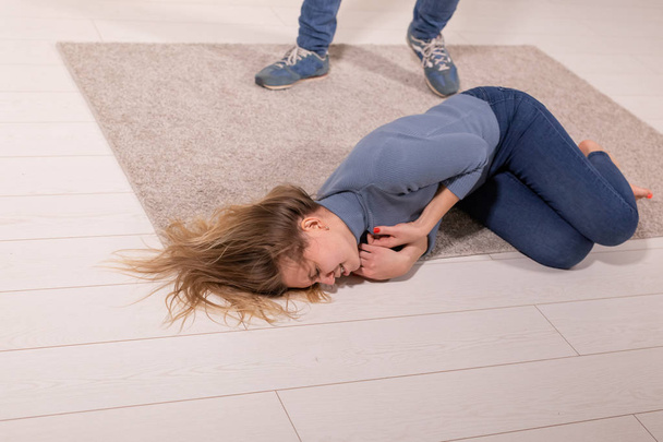 pojęcie osoby, nadużyć i przemocy - kobieta zagrożona przez męża, leżąc na podłodze - Zdjęcie, obraz
