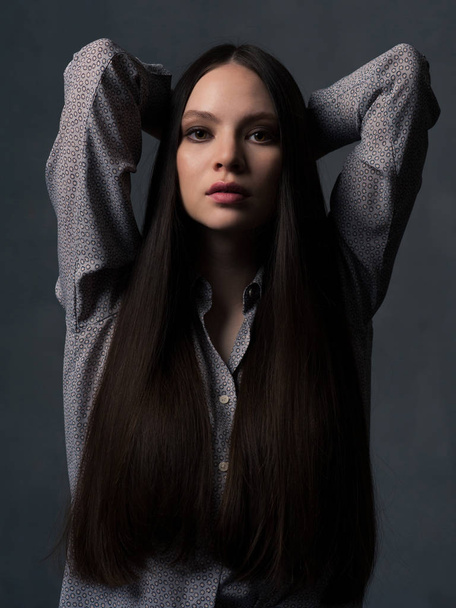 Young woman with long beautiful hair looking at camera - Fotoğraf, Görsel
