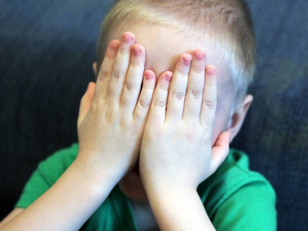 The child covered his face with his hands - Foto, imagen