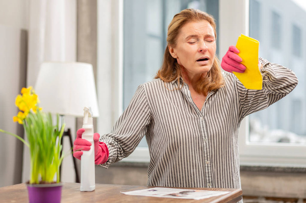 Housewife wearing gloves having sensitivity to cleaning detergents - Fotoğraf, Görsel