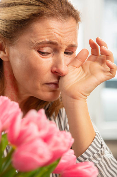 Mature woman feeling awful after receiving flowers from beloved - Fotografie, Obrázek