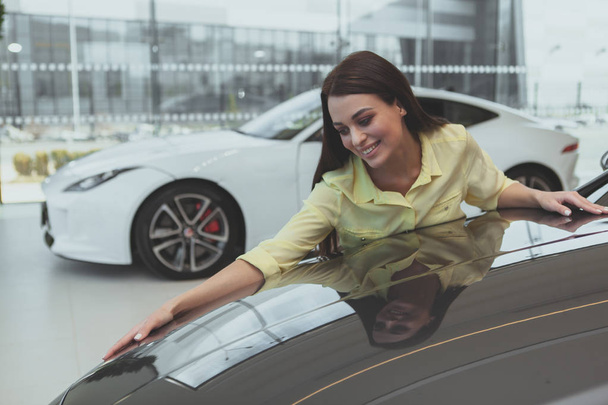 Elegante joven mujer que compra un coche nuevo en la concesionaria
 - Foto, Imagen