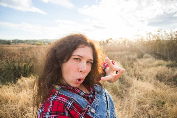 Travel, vacation and holiday concept - Funny young woman taking selfie over beautiful landscape - Fotografie, Obrázek