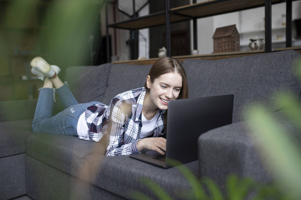 Portret Ładna dziewczyna z laptopem na kanapie - Zdjęcie, obraz