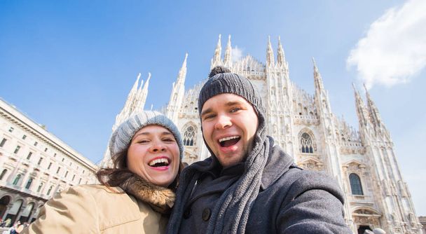 Pareja divertida tomando autorretrato en la plaza Duomo de Milán. Viajes de invierno, Italia y concepto de relación
 - Foto, Imagen