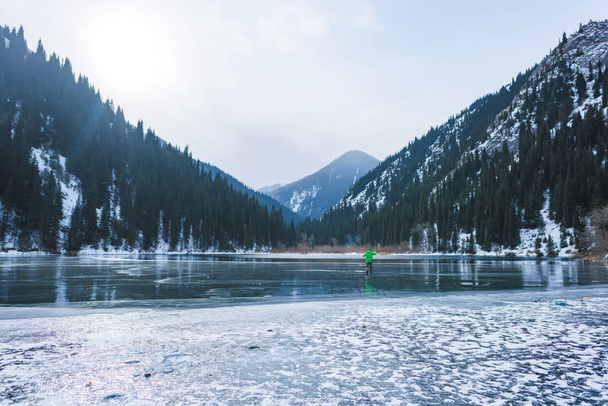 Buz balıkçılık bir dağ gölü. Donmuş gölün yüzeyinde Balık tutma. Bir kış göl kenarında balıkçı. - Fotoğraf, Görsel